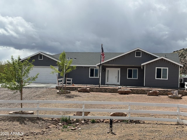 view of front facade with concrete driveway, an attached garage, and a fenced front yard