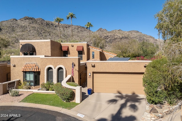 pueblo-style home featuring a mountain view and a garage