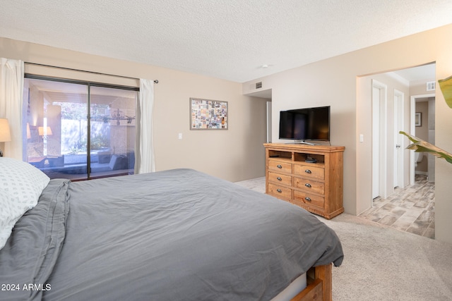 carpeted bedroom featuring a textured ceiling and access to exterior