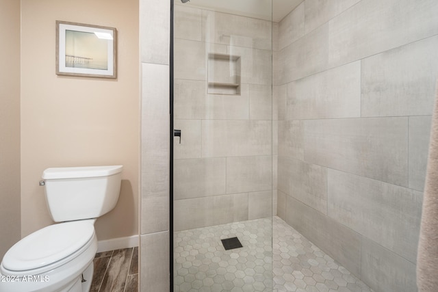 bathroom with toilet and tiled shower