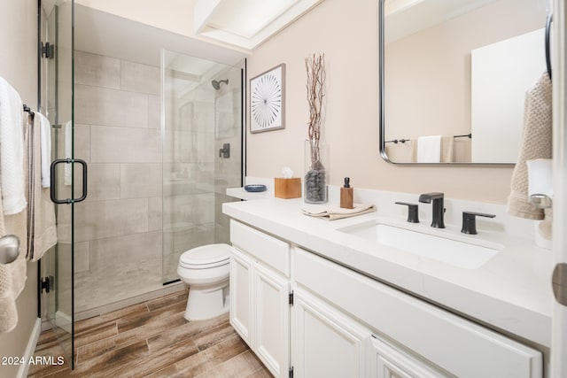 bathroom with vanity, walk in shower, hardwood / wood-style flooring, and toilet