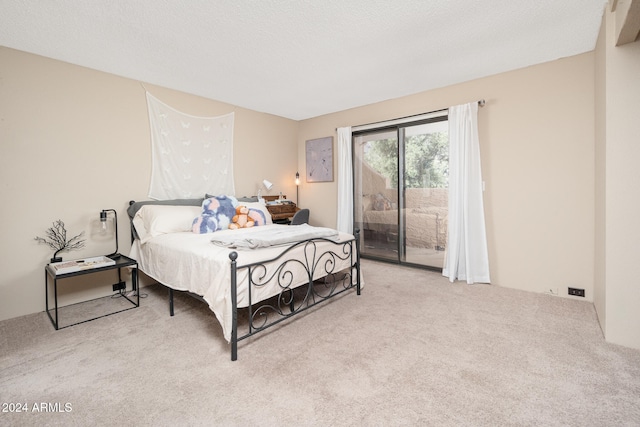 carpeted bedroom with a textured ceiling and access to exterior