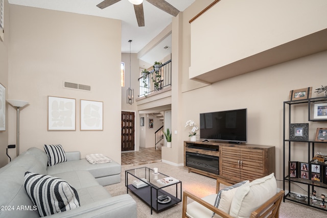 carpeted living room with high vaulted ceiling and ceiling fan