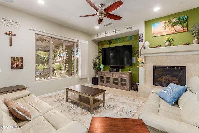 living room with ceiling fan and a fireplace