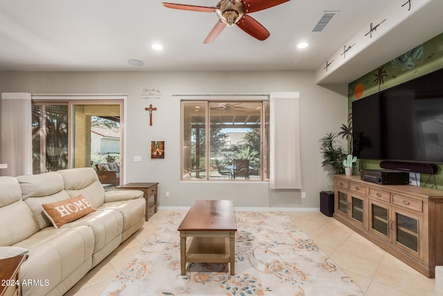 living room with a wealth of natural light, light tile patterned flooring, and ceiling fan