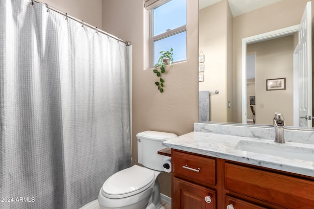 bathroom featuring vanity, toilet, and curtained shower