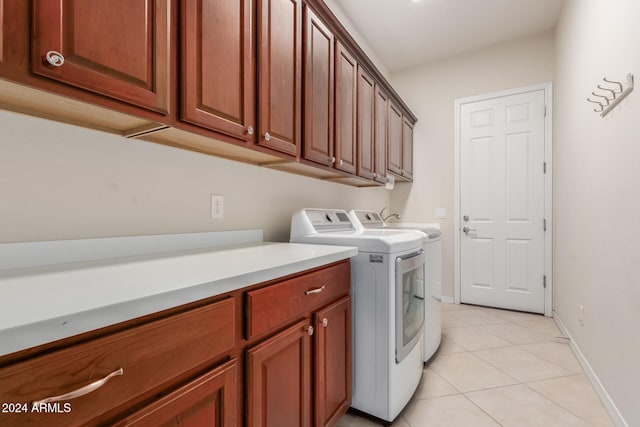 washroom with independent washer and dryer, cabinets, and light tile patterned floors