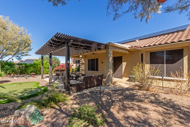 rear view of house featuring solar panels and a patio area