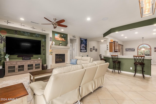 tiled living room featuring a tile fireplace and ceiling fan