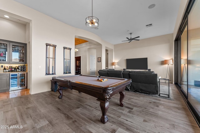 playroom with bar, light hardwood / wood-style floors, billiards, ceiling fan, and beverage cooler