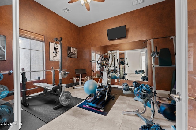 exercise area featuring ceiling fan, a healthy amount of sunlight, and tile patterned flooring