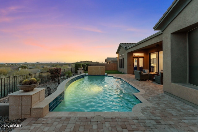 pool at dusk featuring an outdoor living space and a patio area