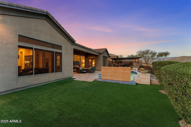 yard at dusk with a patio area and outdoor lounge area