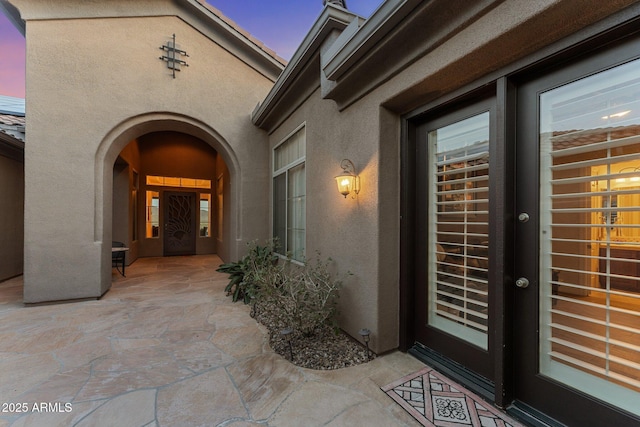 exterior entry at dusk with a patio area