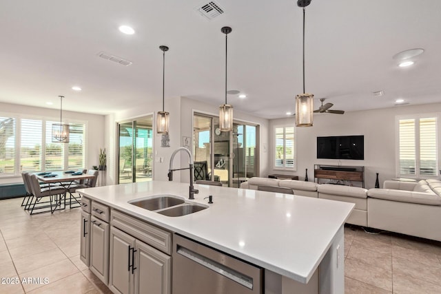 kitchen featuring light countertops, stainless steel dishwasher, a sink, and visible vents