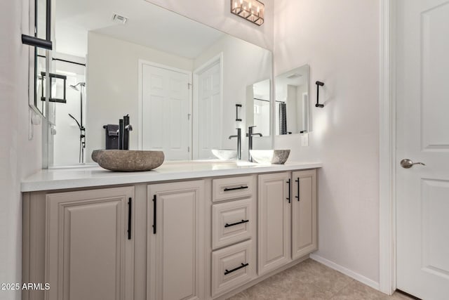 full bathroom with visible vents, a sink, baseboards, and double vanity