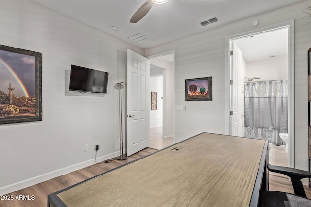 bedroom with a ceiling fan, wood finished floors, visible vents, and baseboards