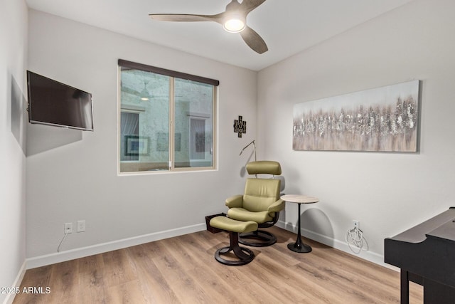 living area with ceiling fan, baseboards, and wood finished floors