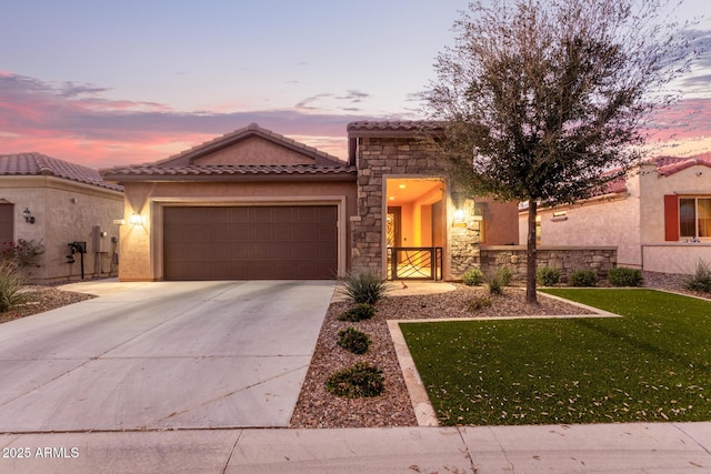 mediterranean / spanish home featuring a tile roof, stucco siding, concrete driveway, a garage, and stone siding