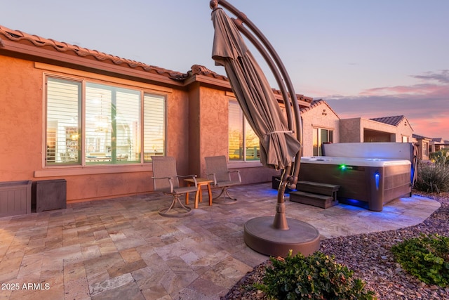 patio terrace at dusk with a hot tub