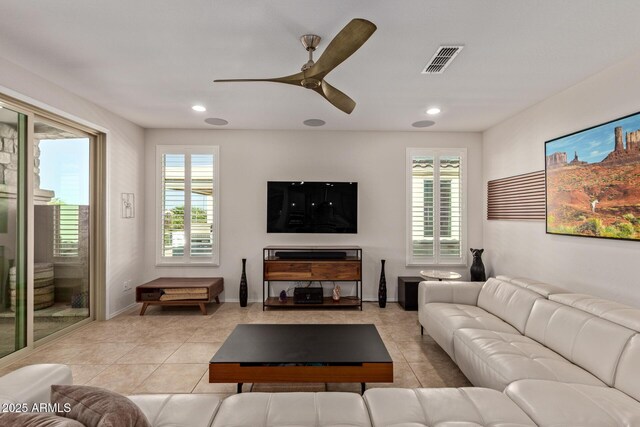 living room featuring light tile patterned floors, ceiling fan, visible vents, and recessed lighting