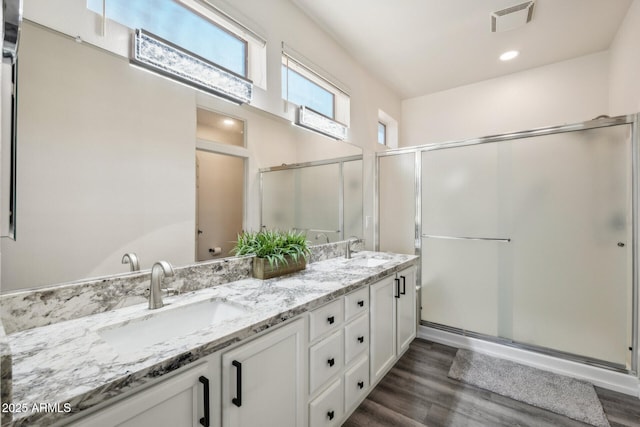 bathroom featuring walk in shower, vanity, and hardwood / wood-style flooring