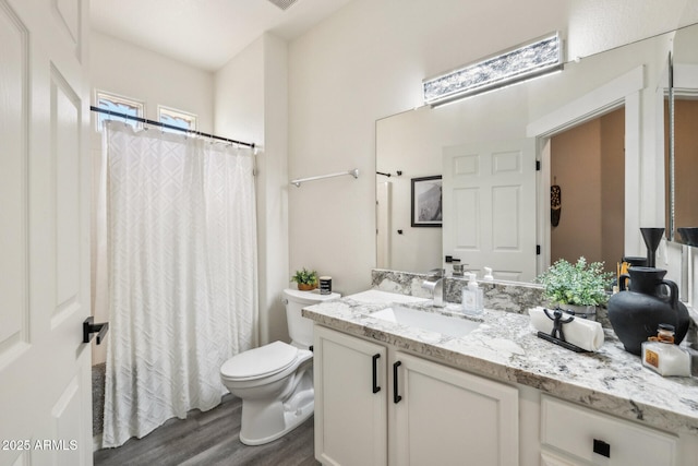 bathroom with toilet, wood-type flooring, and vanity