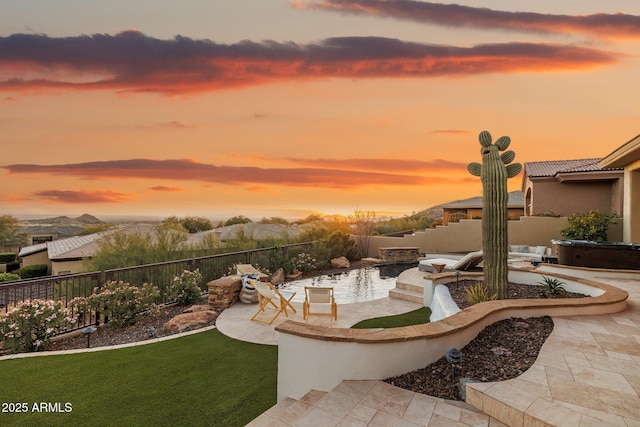 yard at dusk featuring a patio