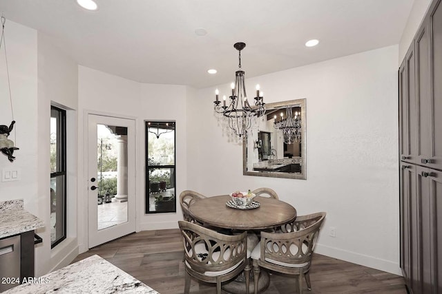 dining space with dark hardwood / wood-style floors and an inviting chandelier