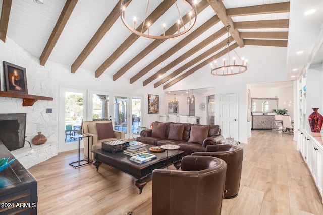 living room with a chandelier, high vaulted ceiling, light hardwood / wood-style flooring, and a stone fireplace