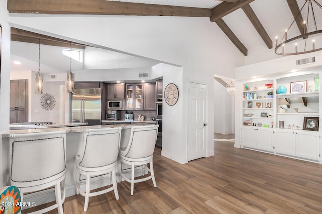 kitchen featuring kitchen peninsula, dark hardwood / wood-style flooring, beam ceiling, built in appliances, and high vaulted ceiling