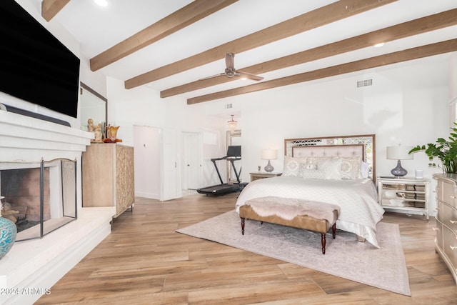 bedroom featuring ceiling fan, beamed ceiling, and light wood-type flooring