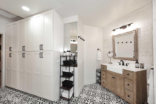 bathroom featuring vanity and tile walls