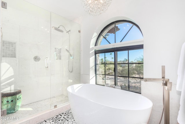 bathroom with an inviting chandelier and independent shower and bath