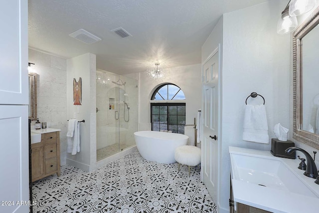 bathroom with a chandelier, shower with separate bathtub, vanity, and a textured ceiling