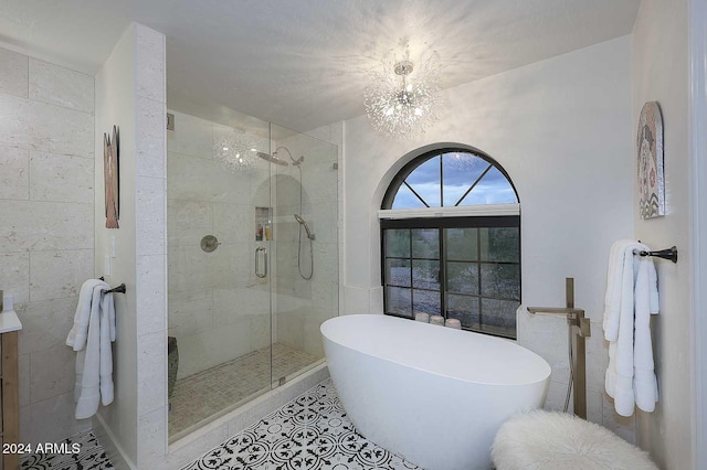 bathroom featuring tile patterned floors, plus walk in shower, and a chandelier