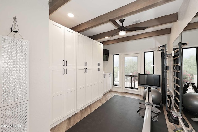 exercise room with ceiling fan and light wood-type flooring