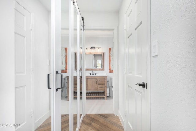 corridor featuring hardwood / wood-style floors and sink