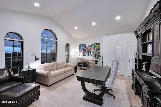 office with high vaulted ceiling and light hardwood / wood-style floors