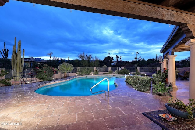 pool at dusk with a patio area