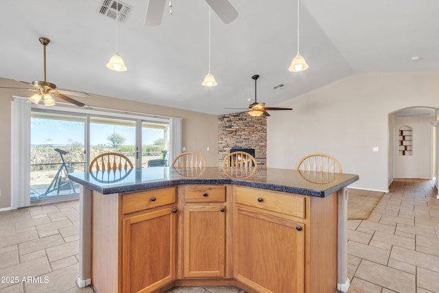 kitchen with vaulted ceiling, a center island, and ceiling fan