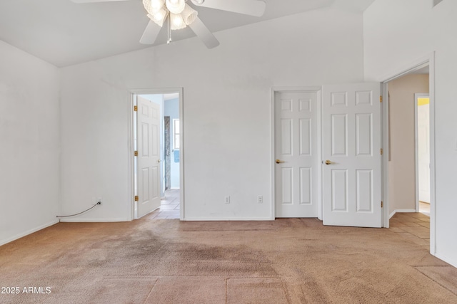 carpeted empty room with vaulted ceiling and ceiling fan