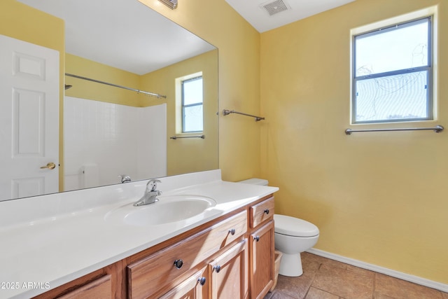 bathroom with vanity, tile patterned flooring, toilet, and walk in shower