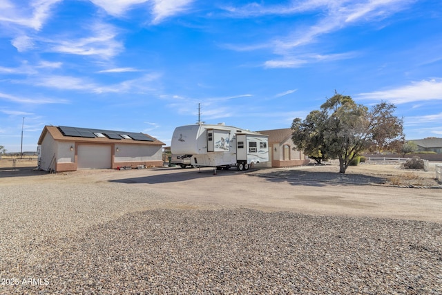 view of front of property featuring a garage and solar panels