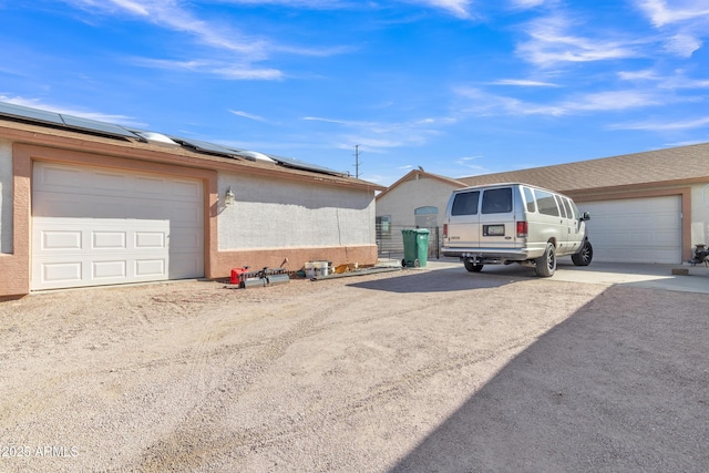 view of side of property with a garage and solar panels