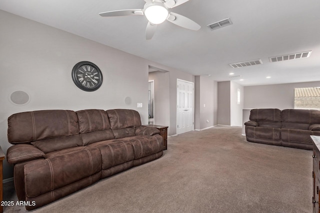 living area with visible vents, carpet floors, and a ceiling fan