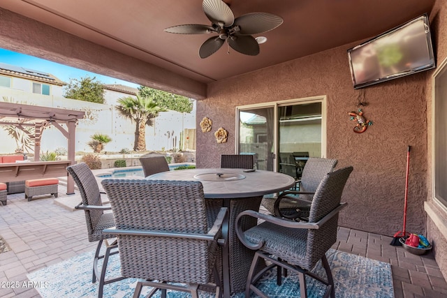 view of patio featuring outdoor dining space, fence, a fenced in pool, and a ceiling fan