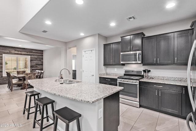 kitchen with a kitchen bar, visible vents, a sink, recessed lighting, and stainless steel appliances