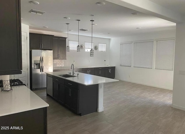 1081 E Armstrong Way, Chandler, AZ 85286 - kitchen with appliances with stainless steel finishes, a sink, light countertops, an island with sink, and recessed lighting
