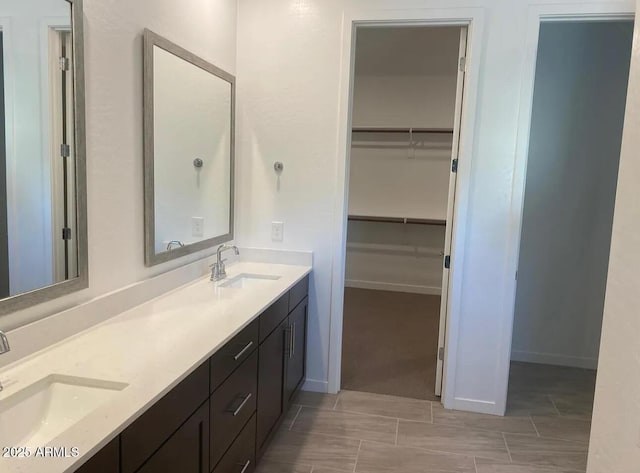 1081 E Armstrong Way, Chandler, AZ 85286 - full bathroom with double vanity, a walk in closet, and baseboards